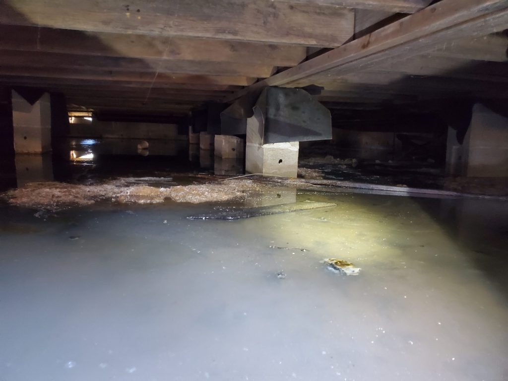 Standing water in a flooded crawl space after a Lexington storm